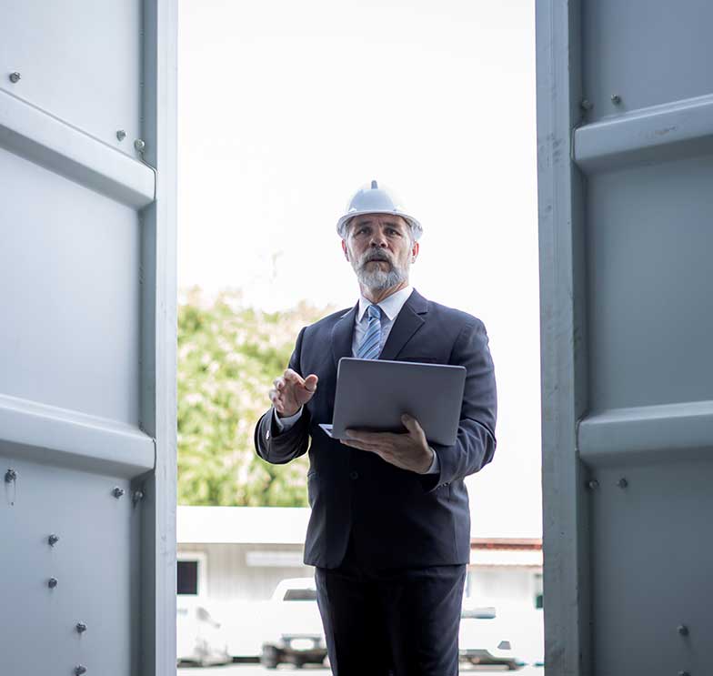 engenheiro civil com capacete e terno na entrada da obra tentando acesso para realizar o laudo quando o vizinho impediu a vistoria.